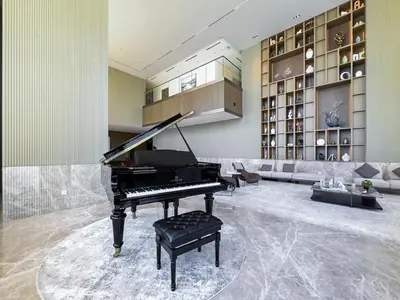 a living room with a piano and a couch at Modern Studio - Pool, Gym & Padel in Dubai