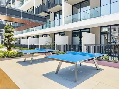 two ping pong tables in front of a building at Modern Studio - Pool, Gym & Padel in Dubai
