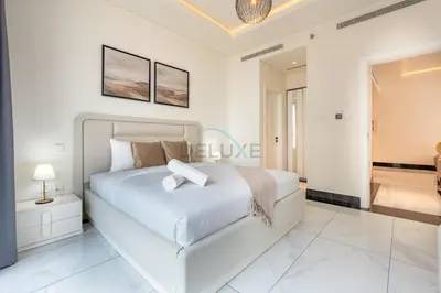 a white bedroom with a large bed and a bathroom at Spacious Balcony with Private Jacuzzi and Stunning Views, Easy Public Transport Access, Terraces Marasi Drive, Business Bay by Deluxe Holiday Homes in Dubai