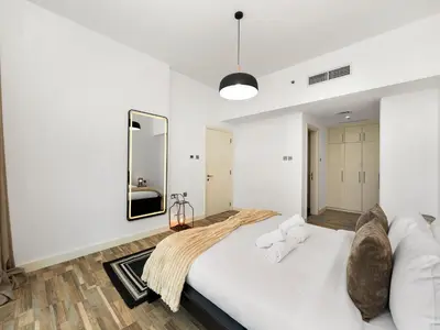 a white bedroom with a large bed and a mirror at 4 BHK Duplex - Marina & JBR - Iconic Dubai Skyline in Dubai