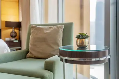 a living room with a green chair and a glass table at Luxury Studio Burj Khalifa View Address Dubai Mall in Dubai