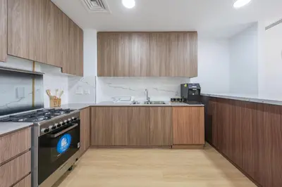 a kitchen with wooden cabinets and a sink and a stove at Luxury Villa 3BR with garden in Dubai