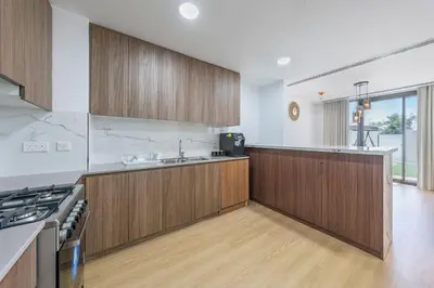 a large kitchen with wooden cabinets and a stove at Luxury Villa 3BR with garden in Dubai