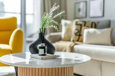 a table with a vase of flowers on it in a living room at 1 Bedroom lagoon by District One in Dubai