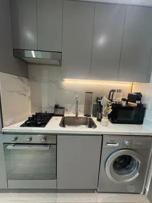 a kitchen with a sink and a washing machine at Luxury Studio Burj Khalifa View in Dubai