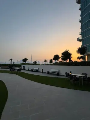 a park with benches and tables with the sunset in the background at Luxury Studio Burj Khalifa View in Dubai