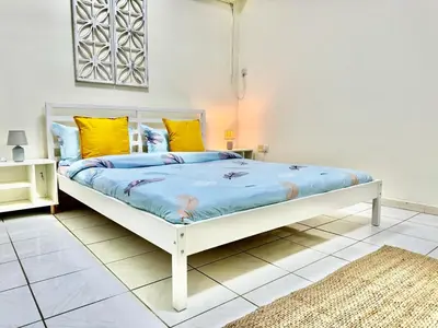 a bedroom with a large white bed with yellow pillows at 5 mins walk to Burjuman metro in Dubai