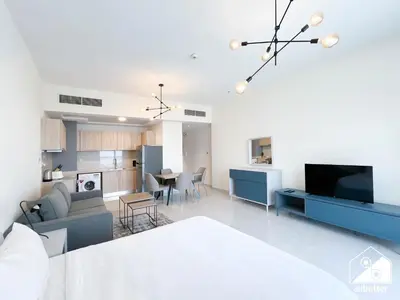 a living room and kitchen with a couch and a tv at City-View Studio in AG Tower l Pool & Gym Access in Dubai