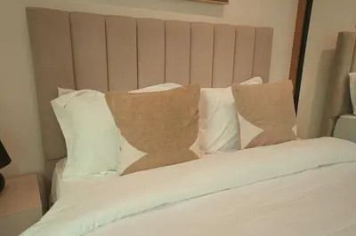 a bed with four pillows on it at Private Jacuzzi 2BR Luxury Unit in Dubai