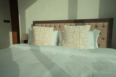 a large bed with white sheets and pillows at Private Jacuzzi 2BR Luxury Unit in Dubai