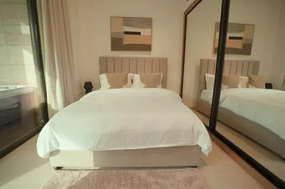 a bedroom with two beds and a large mirror at Private Jacuzzi 2BR Luxury Unit in Dubai