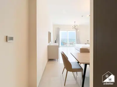 a dining room with a table and a bedroom at Skyline Studio Escape l Balcony , Gym & Pool in Dubai