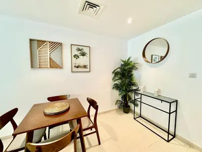 a dining room with a table and a mirror at The Greens very well-lit unit in Dubai