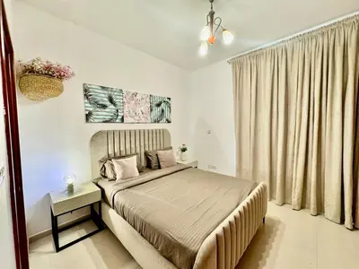 a bedroom with a bed and a large window at The Greens very well-lit unit in Dubai