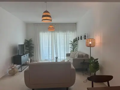 a living room with a couch and a tv at The Greens very well-lit unit in Dubai