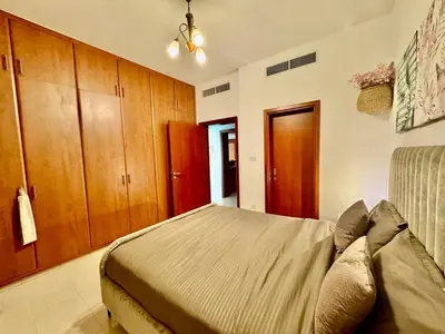 a bedroom with a bed and wooden cabinets at The Greens very well-lit unit in Dubai