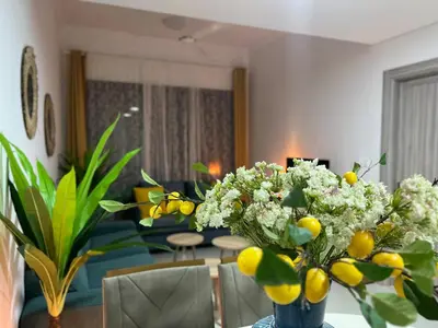 a living room with a table with a vase of flowers at 1 min to ADCB metro New home in Dubai