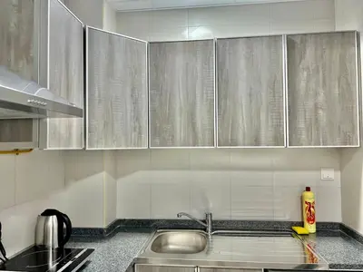 a kitchen with stainless steel cabinets and a sink at 1 min to ADCB metro New home in Dubai