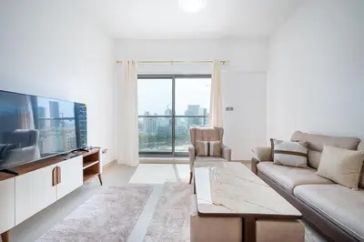 a living room with a couch and a tv at Contemporary 1BHK with Home Feel in Dubai