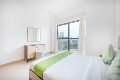 a bedroom with a bed and a large window at Contemporary 1BHK with Home Feel in Dubai