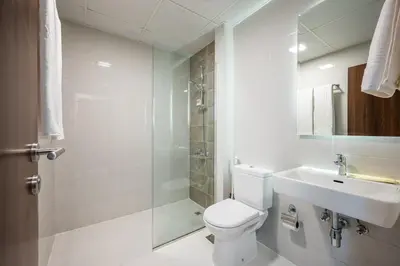 a bathroom with a toilet and a sink and a shower at Contemporary 1BHK with Home Feel in Dubai