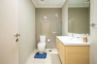 a bathroom with a toilet and a sink and a mirror at 1BHK Retreat Peaceful & Bright in Dubai