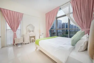a bedroom with a bed with pink curtains and a window at 1BHK Retreat Peaceful & Bright in Dubai
