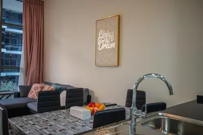 a living room with a couch and a kitchen with a sink at 1BHK Retreat Peaceful & Bright in Dubai