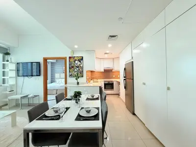 a kitchen and living room with a table and chairs at Ocean Heights New 2BDR with full Sea & Dubai Eye view in Marina by Simplex Home in Dubai