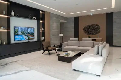 a living room with a couch and a tv at Lux Sobha Hartland 1 BR with 5 Star Resort Amenities in Dubai