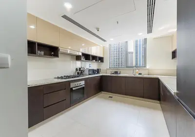 a large kitchen with wooden cabinets and a large window at Stunning 2 Bedroom at Dubai Creek in Dubai