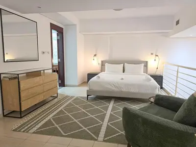 a bedroom with a bed and a mirror and a couch at HiGuests - Huge Duplex for Creative Inspiration! in Dubai