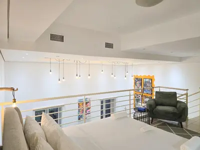 a living room with a bed and a chair at HiGuests - Huge Duplex for Creative Inspiration! in Dubai