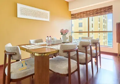 a dining room with a wooden table and chairs at Beachfront 2BR, Sea & Ain Dubai View, JBR Walk Hosted by Desert City Stays in Dubai