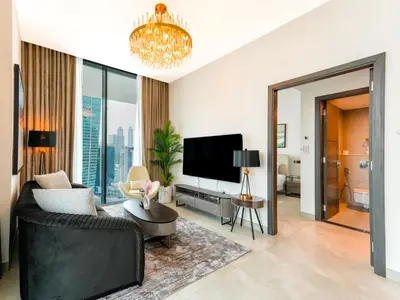 a living room with a couch and a tv at Luxury Smart 1BR -High Floor Business Bay Views in Dubai