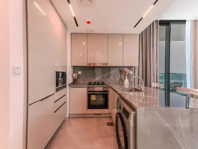 a kitchen with white cabinets and a stove top oven at Luxury Smart 1BR -High Floor Business Bay Views in Dubai