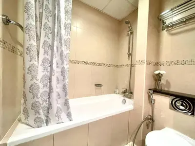 a bathroom with a tub and a shower curtain at Higuests - Close to METRO Charming Studio with Lake Views in Dubai