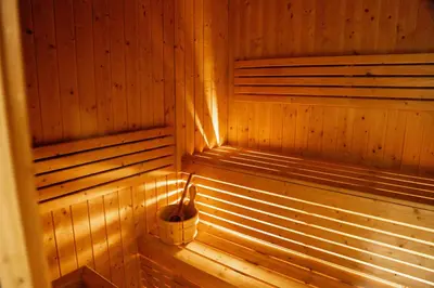 a wooden sauna with a bucket in the corner at Cozy 1BR with Canal Views in Business Bay in Dubai