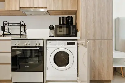 a kitchen with a washing machine and a microwave at BLVD - Urban Oasis Missoni 10 - Min to Dubai Mall in Dubai