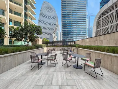 a patio with tables and chairs and buildings at BLVD - Urban Oasis Missoni 10 - Min to Dubai Mall in Dubai