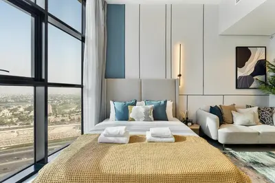 a bedroom with a large bed and a couch at Modern Studio - near Dubai Hills Mall - Pool & Gym in Dubai