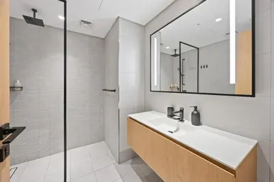 a white bathroom with a sink and a mirror at Modern Studio in Business Bay, Stylish & Central in Dubai