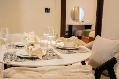 a white table with plates and glasses on it at Stylish 1BR with Stunning Canal Views in Business Bay in Dubai