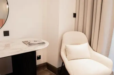 a white chair in a room with a mirror at Stylish 1BR with Stunning Canal Views in Business Bay in Dubai