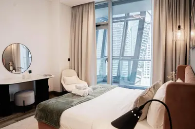 a hotel room with a bed and a desk and a window at Spacious 1BR in Business Bay l Pool, Gym & Parking in Dubai