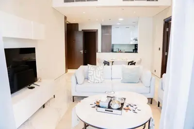 a living room with two white couches and a table at Spacious 1BR in Business Bay l Pool, Gym & Parking in Dubai