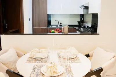 a white table with plates and napkins on it in a kitchen at Spacious 1BR in Business Bay l Pool, Gym & Parking in Dubai