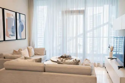 a living room with a couch and a large window at Spacious 1BR in Business Bay l Pool, Gym & Parking in Dubai