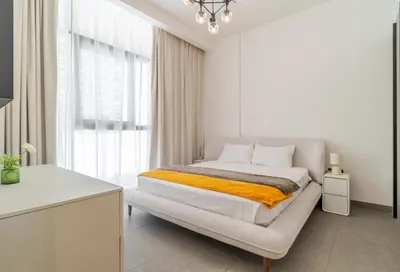 a white bedroom with a bed and a window at Oxford Luxury 1 bedroom & study in Dubai