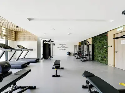 a gym with several treadmills and machines in it at Oxford Luxury 1 bedroom & study in Dubai